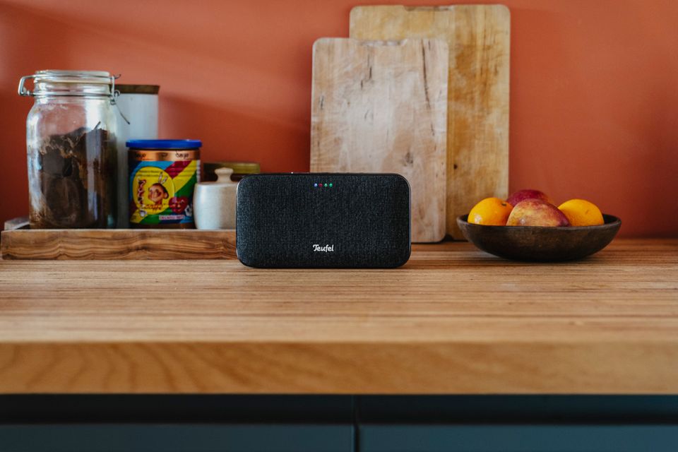 Stylischer WLAN-Lautsprecher in Schwarz auf einer Küchenarbeitsplatte aus Holz
