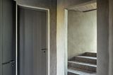 Kleine Diele mit lehmverputzten Wänden und Treppe zum Obergeschoss