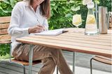 Lina Rickardsson auf ihrem Balkon mit Holztisch und Glaskaraffe