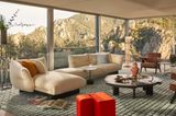 Beigefarbenes Sofa vor einer verglasten Wohnzimmerfront mit Bergpanorama