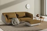 Sofa in Creme und Braun auf einem gestreiften Teppich mit grauem Plaid
