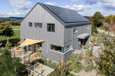 Holzhaus mit grauer Fassade und Garten