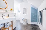 Badezimmer mit grauen Bodenfließen, weißen Wandfließen und blauen Metrofließen in der Dusche