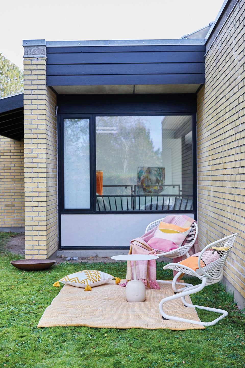 Outdoor-Möbel von LIV Interior stehen auf einem Teppich in einem Garten