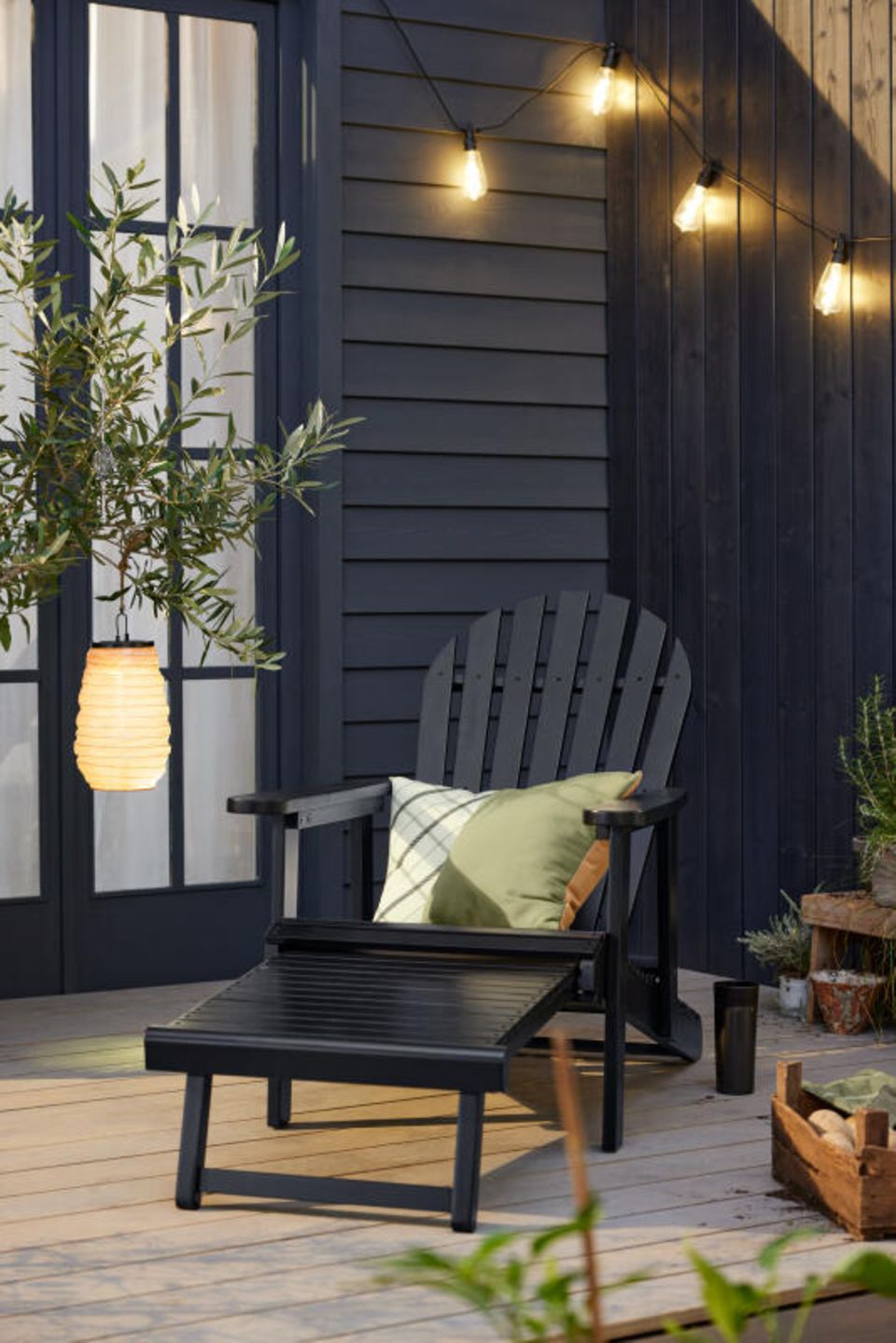 Liegestuhl auf einer Terrasse mit Lampion und Lichterkette