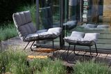 Schaukelstuhl mit grauem Sitzpolster im Garten