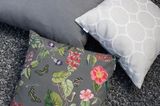 Drei graue Kissen, davon eins mit floralem Muster
