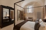 Schlafzimmer mit Himmelbett in dunklem Holz und Spiegelschrank