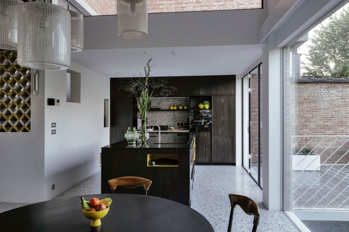 Offene Küche mit Terrazzoboden und Einrichtung in dunklem Holz