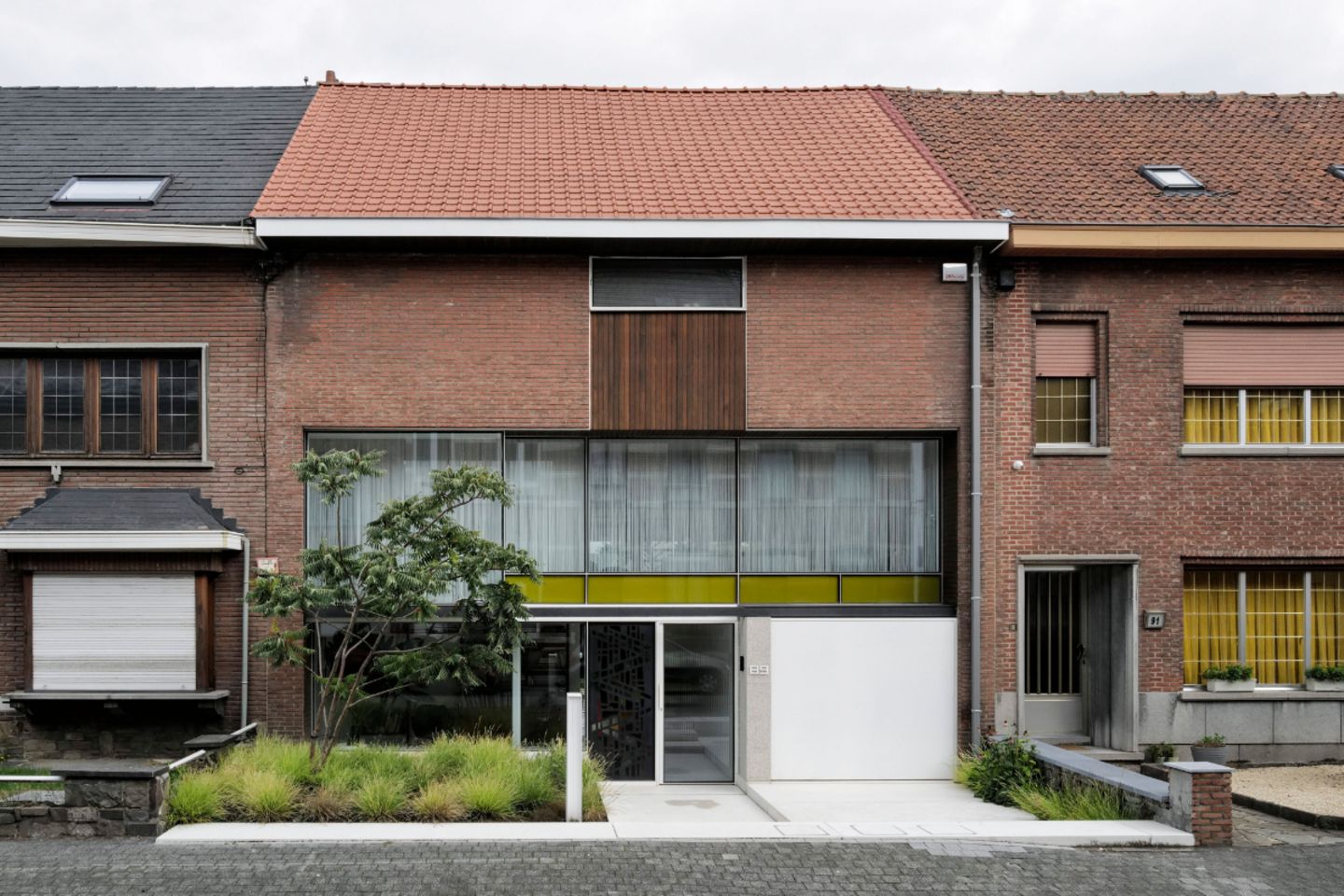 Dreigeschossige Hausfassade mit farbigen Glaspaneelen