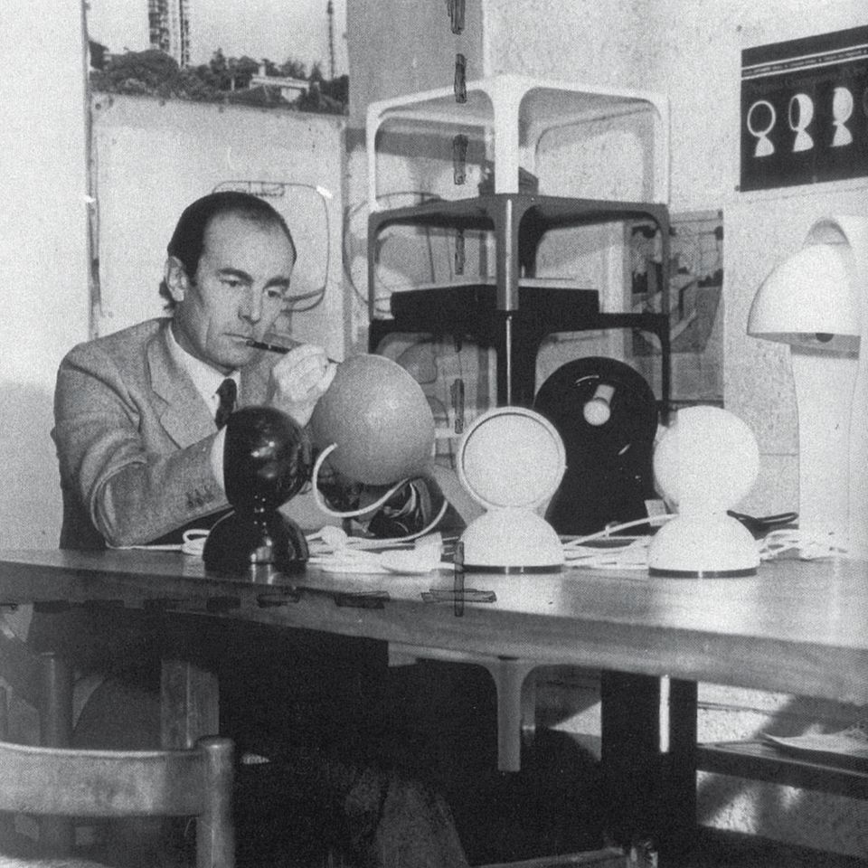 Vico Magistretti (1920–2006) war ein Mailänder Architekt, der ab den 1960er-Jahren auch als Industriedesigner tätig war. Mit Entwürfen, die neben der Funktionalität oftmals auch einen spielerischen Aspekt haben, sowie durch seine Lehrtätigkeit und als Kreativchef von De Padova prägte Magistretti unsere Vorstellung von italienischem Design. Als Klassiker gelten heute nicht nur die Nachttischleuchte "Eclisse", sondern auch sein Sofa "Maralunga" für Cassina oder die Leuchte "Atollo" für Oluce.