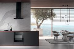 Offene Küche mit schwarzen Küchenfronten und angeschlossenem Wohnzimmer mit Blick aufs Meer