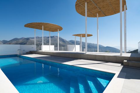 Dachterrasse mit Pool und hohen Bambusschirmen