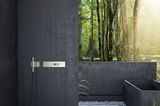 Outdoor-Dusche aus gemauertem Beton mit Deckenbrause und Blick auf Natur