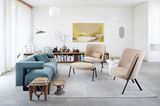 Wohnzimmer mit türkisfarbenem Sofa und beigen Sesseln