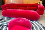 Pinkes Sofa vor apricotfarbenem Hintergrund