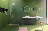 Badezimmer mit grüner Wandverkleideung und weißen Armaturen und Spiegeln