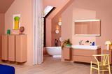 Badmöbel und Wand in Terrakotta mit Waschbecken und Badewanne in weiß und bunten Accessoires