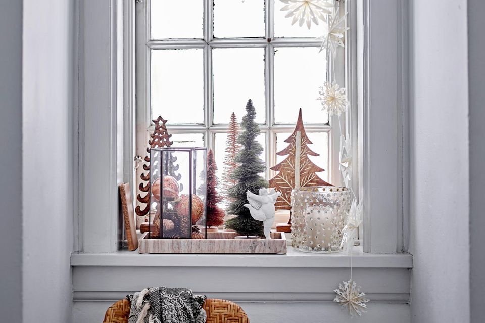 Weihnachtsdeko steht auf einer Fensterbank