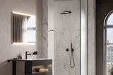 Badezimmer mit schwarzem Waschtisch und Dusche mit Marmor-Fliesen und -Rückwand