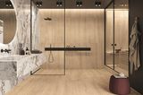 Badezimmer mit Marmor-Waschbecken und Fliesen in Holzoptik