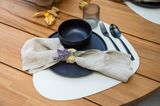 Serviettenring aus Bast und Lavendel drapiert auf einem Teller