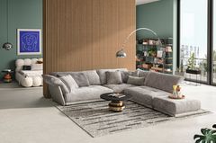 Graues Sofa mit einem Beistelltisch in Schwarz-Gold mit einer Holzpaneele im Hintergrund