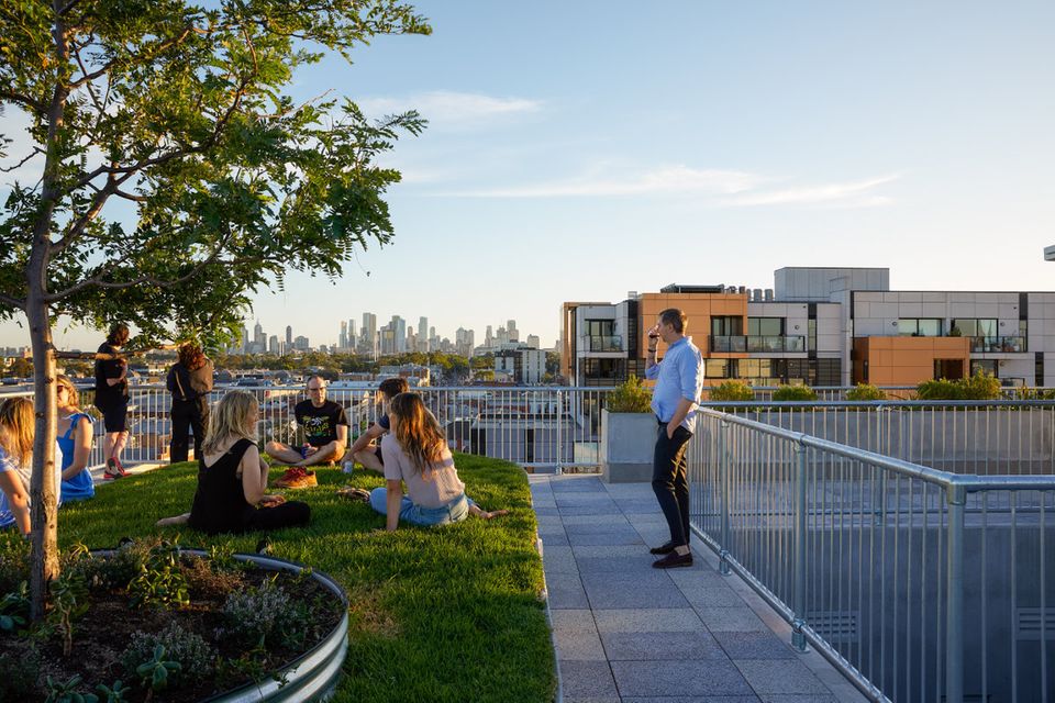 Begrünter Dachgarten mit Menschen und Ausblick auf Melbourne