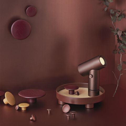 Rote Wand mit roten Knäufen, davor ein Tablett mit roter Leuchte